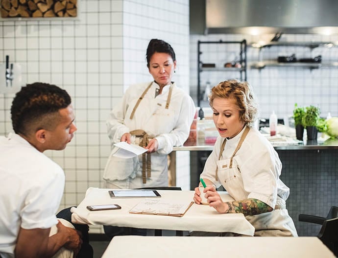 两名 Intertek 志愿者在教室里与年幼的孩子一起微笑